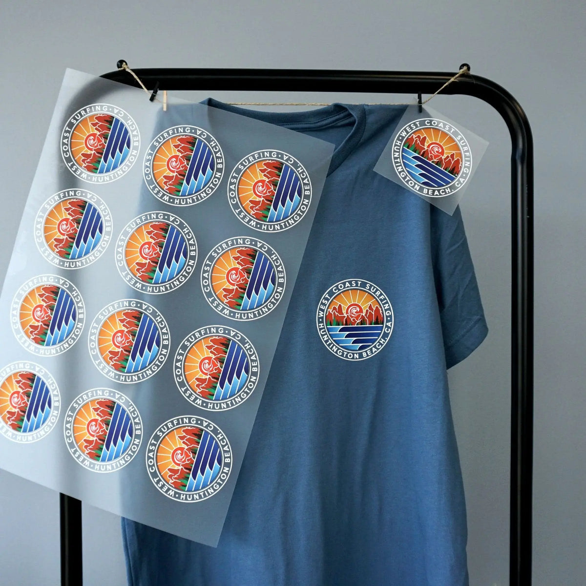 Printed DTF gang sheet with repeated round logos beside a blue shirt.