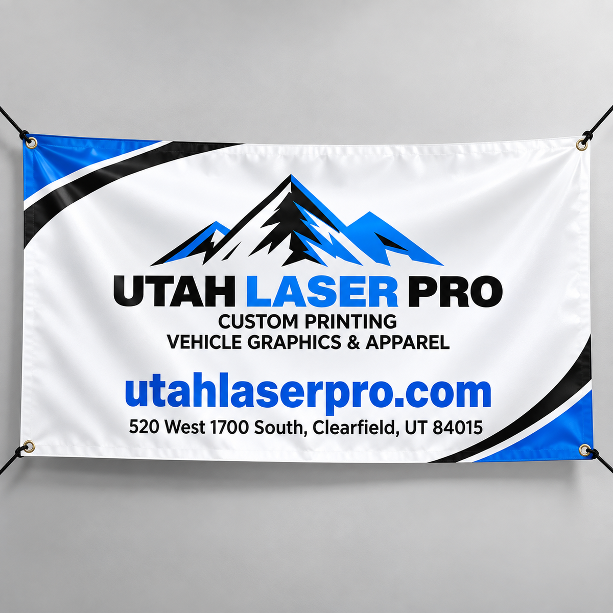 Mockup of a blue, black and white Utah Laser Pro banner with logo, website, Clearfield address and corner grommets.